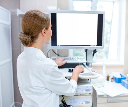 Enfermera revisando imágenes en un monitor.