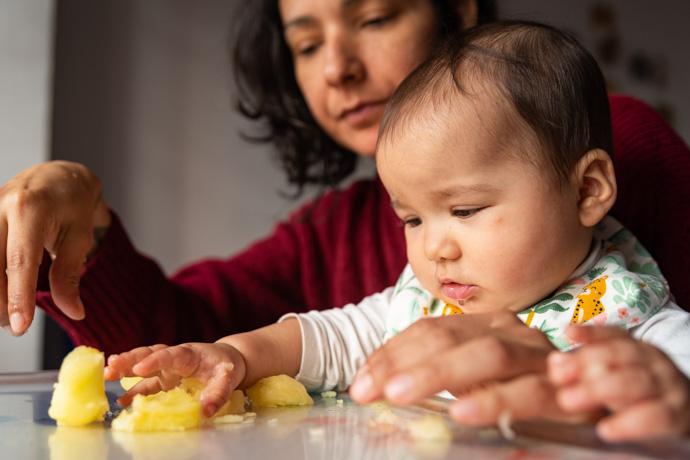 Madre cuidando a su hijo para que no tome alimentos prohibidos por el BLW.
