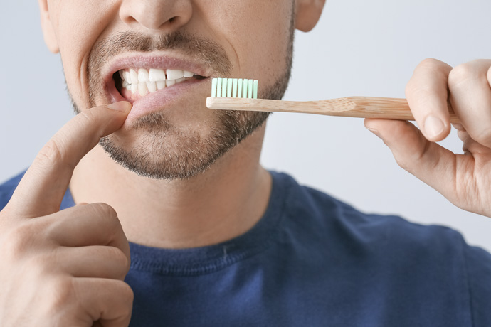 Hombre se lava los dientes y las encías