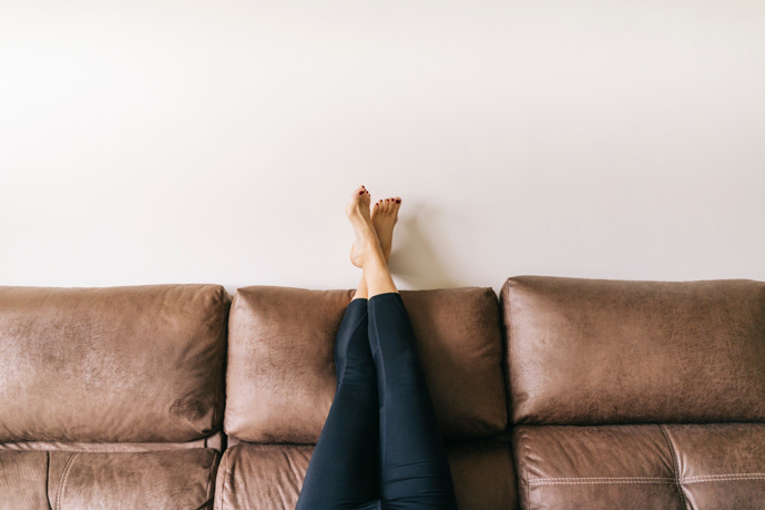 mujer tumbada con piernas en alto