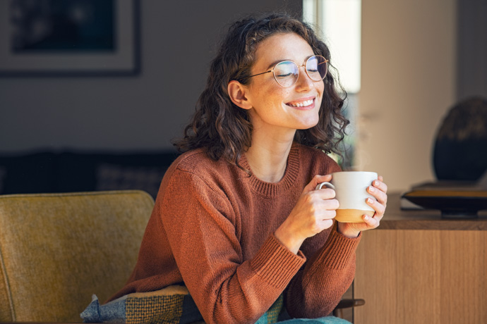 Una mujer feliz tras haber bebido una infusión para bajar el cortisol.