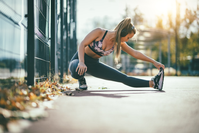 Mujer joven haciendo calentamientos deportivos.