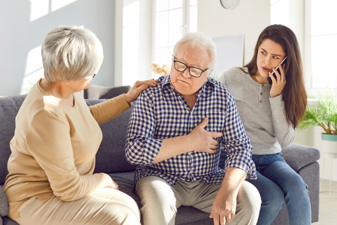 Anciano con su familia preguntándose si se puede recuperar un corazón débil. 