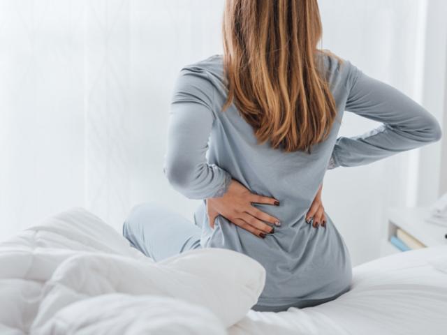 Mujer con dolores de espalda y cáncer.