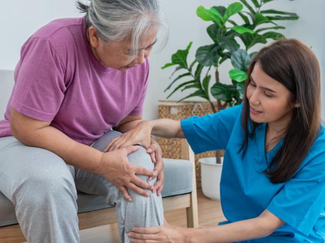 Enfermera ayuda a mujer con artrosis