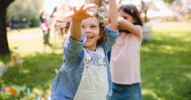 Niñas jugando con burbujas en el parque